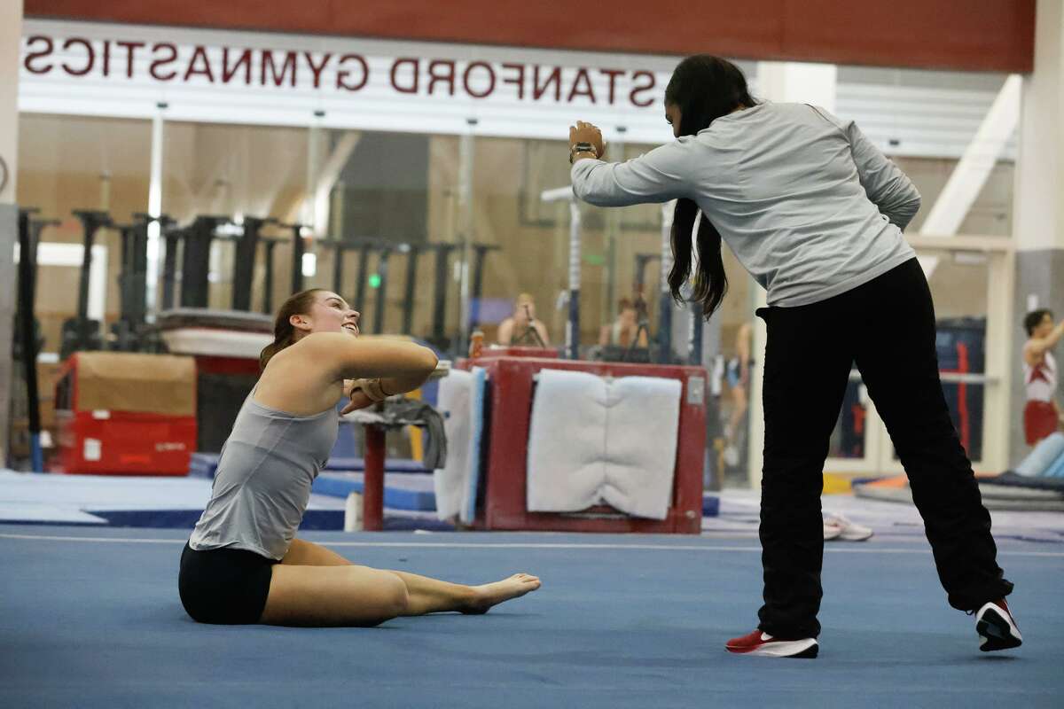 Madison Brunette (l and r), women’s gymnastics team member, and Hallie Mossett, assistant coach of Women’s Gymnastics, high five after Brunette performed a routine on the floor during practice at the Burnham Pavilion & Ford Center at Stanford University on Tuesday, January 10, 2023 in Stanford, Calif.