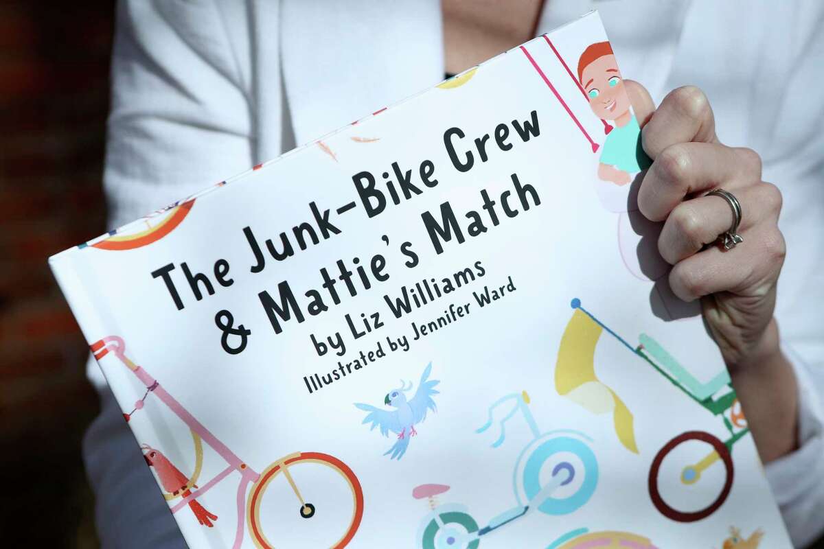 Liz Williams poses for a portrait with her book “The Junk-Bike Crew & Mattie’s Match”, Friday, Jan. 13, 2023, in The Woodlands. Williams is a bone marrow transplant survivor who wrote a children's book for kids undergoing treatment. The book will be released at the end of January on the anniversary of her treatment.