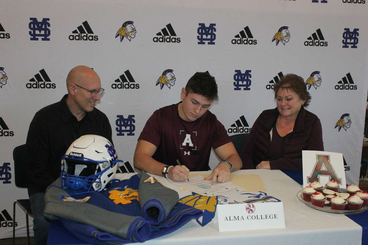 Morley Stanwood linebacker Zayne Moore signs a national letter of intent on Friday to play football at Alma College. He is pictured with his parents, John and Kellie Moore.