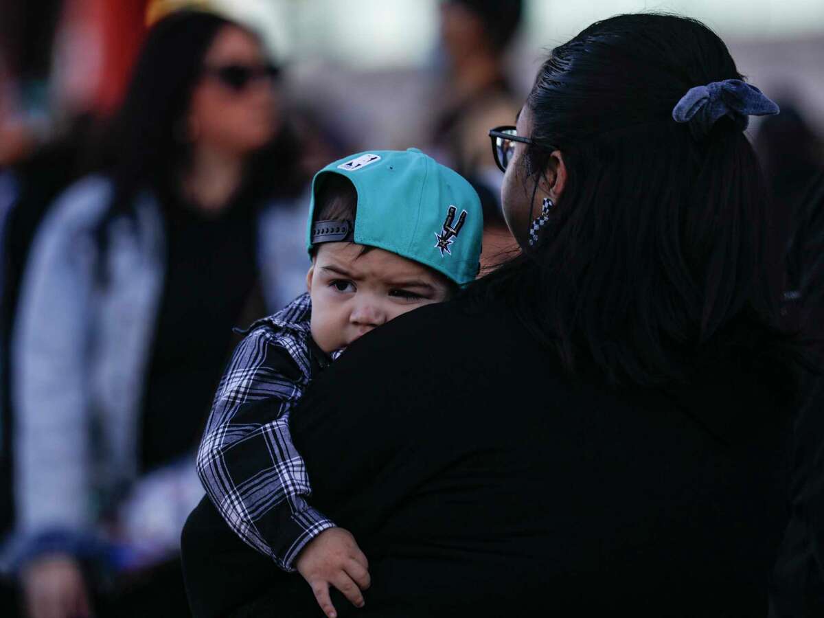 Gio Jax Espinosa, 1, rests on the shoulder of his mother Savannah Espinosa as they wait for other members of their family to arrive to watch the San Antonio Spurs play the Golden State Warriors at the Alamodome in San Antonio. Texas, Friday, January.  13, 2023.