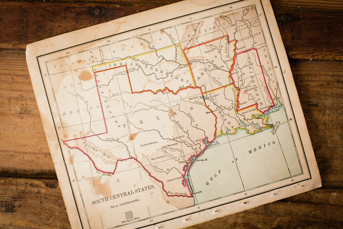 Color image of an old map of South Central (United) States, sitting at an angle on antique wood trunk.