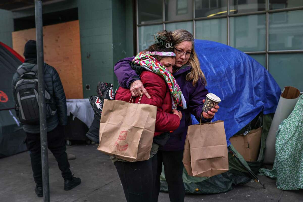 Laurie Steves (right) hugs her daughter Jessica Didia, 35, who is homeless and struggles with drug addiction, outside of her tent on Seventh Street in San Francisco.