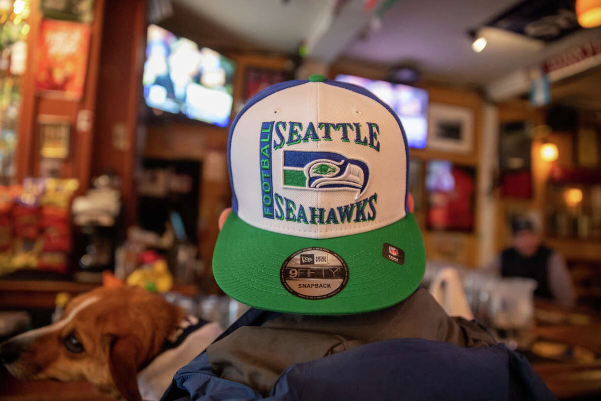 Seattle Seahawks fan Reed Fife wears a Seahawks hat while holding his dog Lupe at Danny Coyle's on Haight Street in San Francisco on Jan. 13.