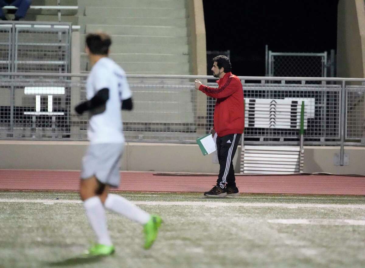 Alief Taylor head soccer coach Jose Leal coaches against his son, Emiliano Leal’s (on the field in the foreground) Tompkins high school team during the first half of a nondistrict boys soccer game at Crump Stadium on Friday, Jan. 13, 2023 in Houston.