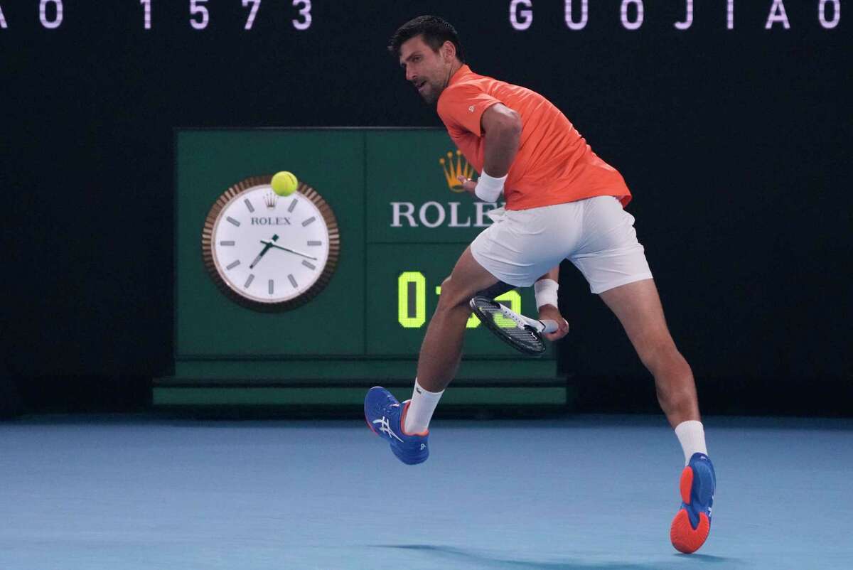 Serbia’s Novak Djokovic plays a shot back between his legs during an exhibition match against Australia’s Nick Kyrgios ahead of the Australian Open in Melbourne.