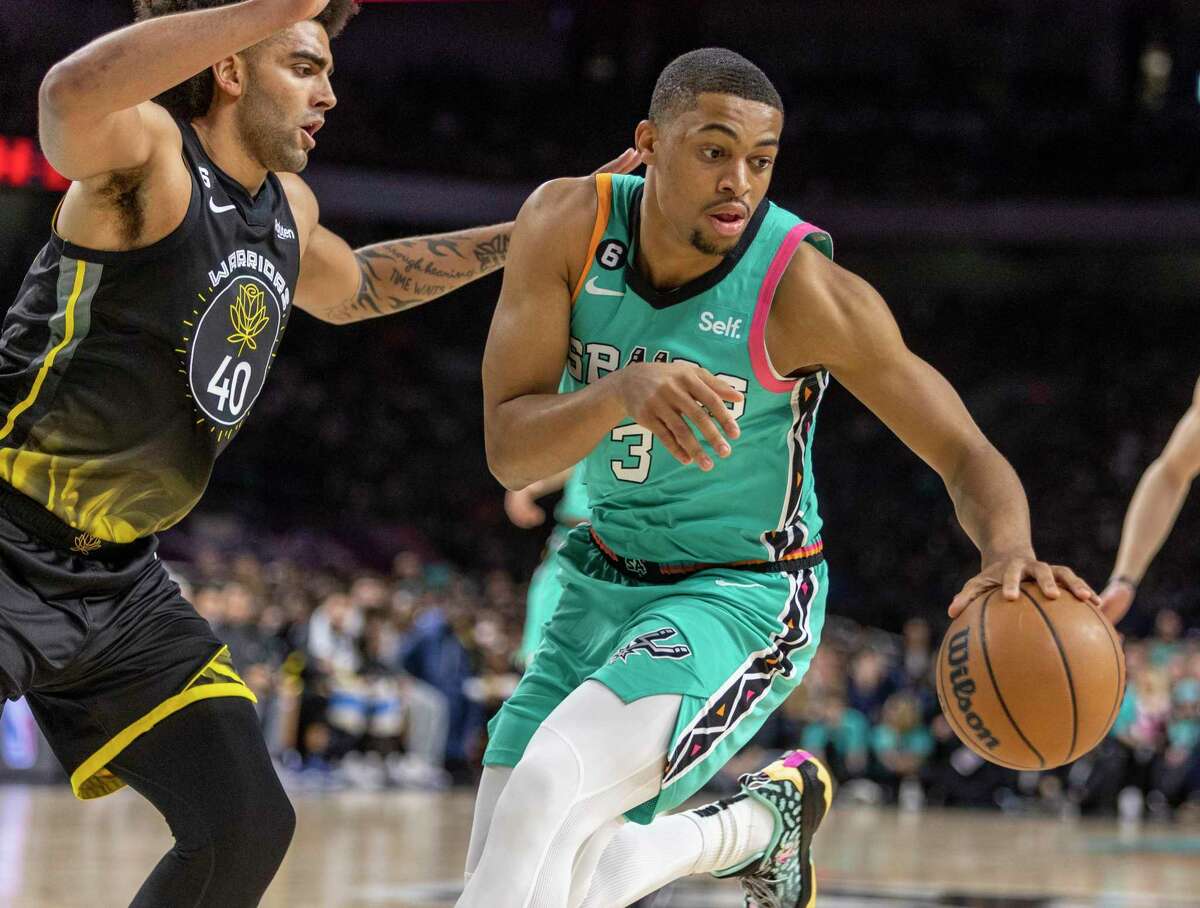 San Antonio Spurs forward Keldon Johnson (3) drives Friday, Jan. 13, 2023 away from Golden State Warriors forward Anthony Lamb (40) during the first half of the Spur’s game against the Warriors in the Alamodome.