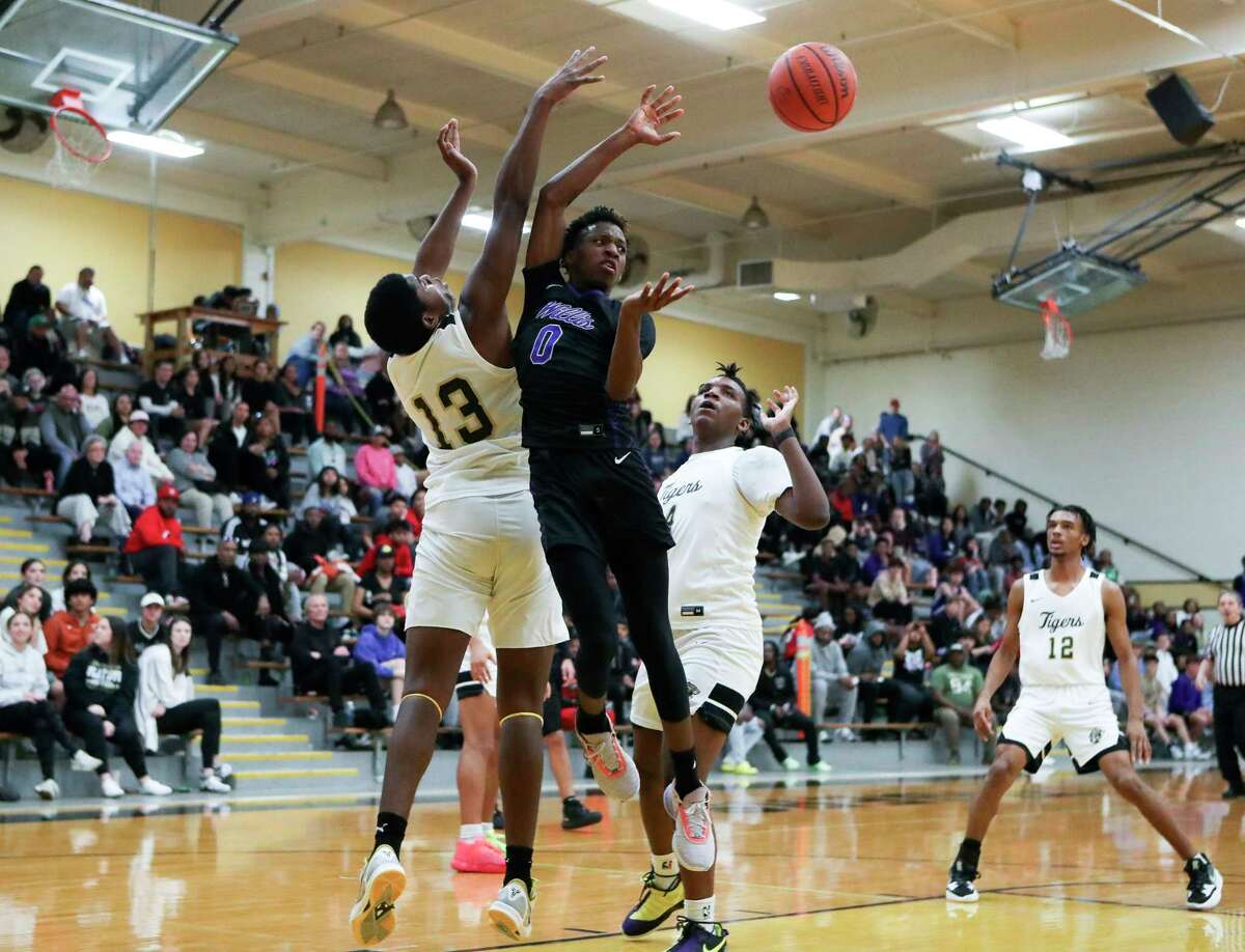 Willis' Tyshon Nixon (0) makes a pass between Conroe’s Buddy Roberts and Gary Lewis (4) in the fourth quarter of a District 13-6A high school basketball game at Conroe High School, Saturday, Jan. 14, 2023, in Conroe.