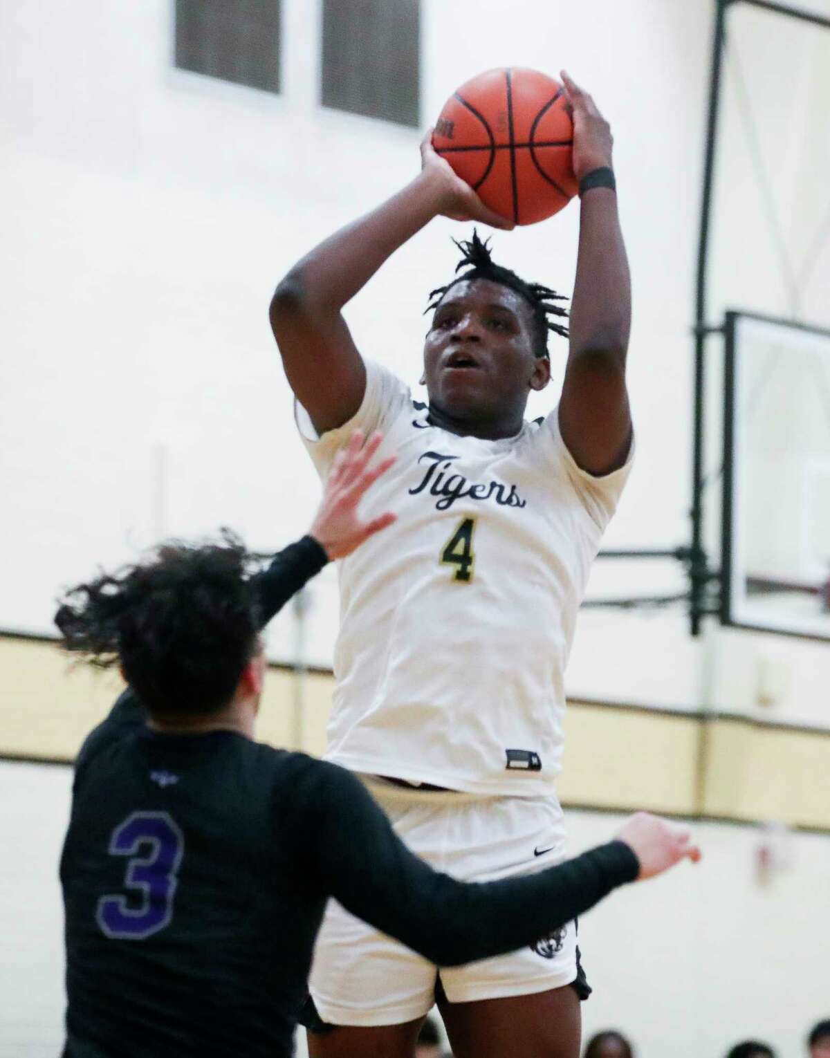 Conroe’s Gary Lewis (4) shoots over Willis' Julian Pelayo (3) in the fourth quarter of a District 13-6A high school basketball game at Conroe High School, Saturday, Jan. 14, 2023, in Conroe.