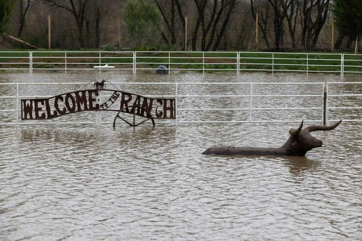安德鲁·托普(Andrew Tope)在萨利纳斯(Salinas)的房产上，一个欢迎标志立在洪水上方，绰号“牧场”。