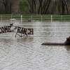 A welcome sign stands above floodwater on Andrew Tope’s Salinas property, nicknamed “The Ranch.”