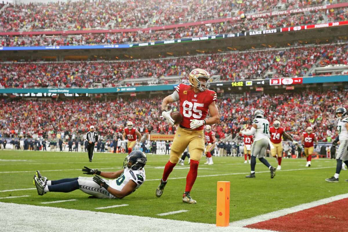 San Francisco 49ers tight end George Kittle (85) scores on a two-point conversion following the touchdown by 49ers running back Elijah Mitchell (25) in the fourth quarter of an NFL wild-card round playoff game against the Seattle Seahawks at Levi’s Stadium in Santa Clara, Calif., Saturday, Jan. 14, 2023.