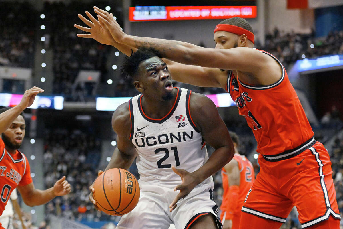 UConn's Adama Sanogo (21) looks to shoot as St. John's Joel Soriano defends in the first half of an NCAA college basketball game, Sunday, Jan. 15, 2023, in Hartford, Conn. (AP Photo/Jessica Hill)