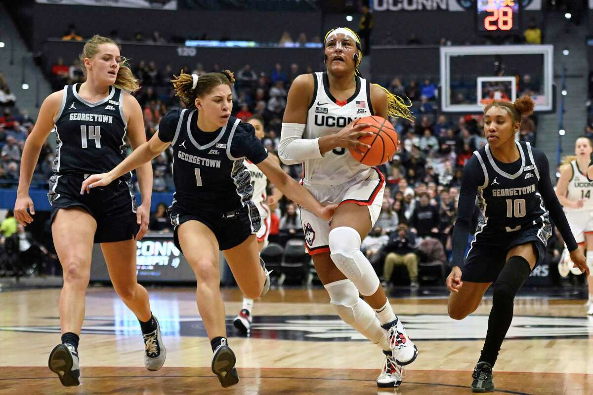 UConn's Aaliyah Edwards, second from right, advances to the basket after stealing the ball while pursued by Georgetown's Kristina Moore (14), Kelsey Ransom (1) and Kennedy Fauntleroy (10) in the second half of an NCAA college basketball game, Sunday, Jan. 15, 2023, in Hartford, Conn.