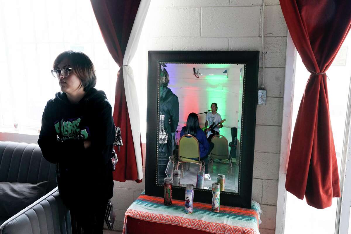 Jaz listens to the band “Atomic Boredon” during a benefit Sunday to help raise funds for Oscar de la Tienda, an eclectic convenience store in the Alta Vista neighborhood that serves as a hub for other small businesses and local artists without brick and mortar shops of their own. Gomez said construction has severely impacted business and the store is “hanging on by a thread, operating at 25% of what average revenues should be.”