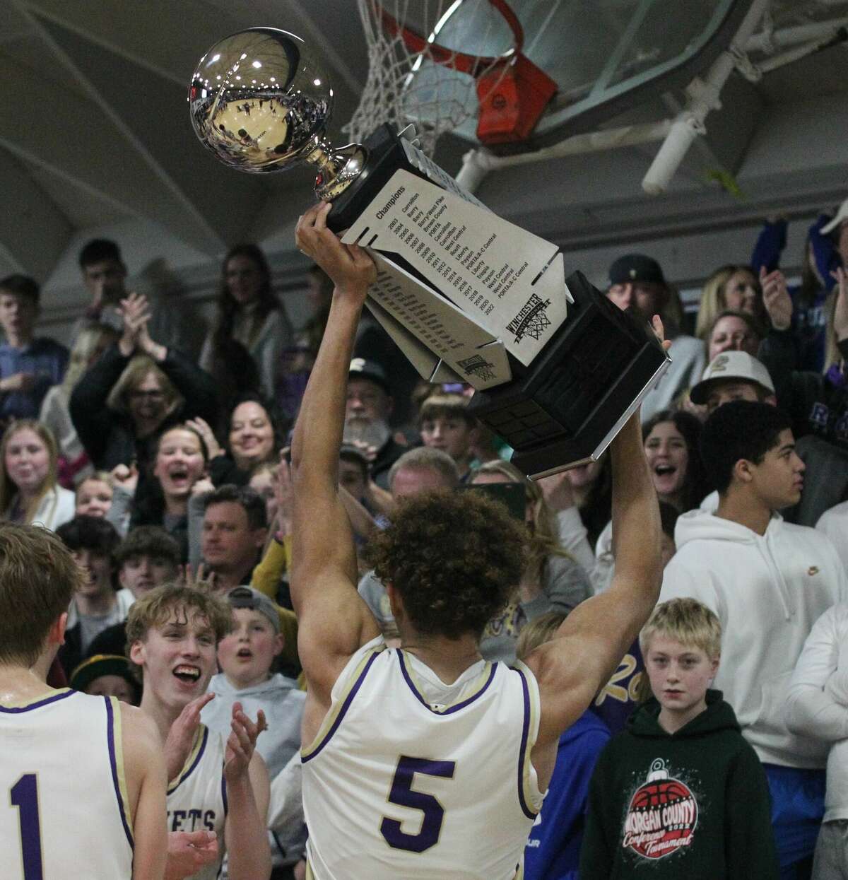 Routt fans cheer as Michael Wilson hoists the trophy after the Rockets beat PORTA/A-C Central to win the championship of the 100th Winchester Invitational Tournament Saturday night in Winchester.