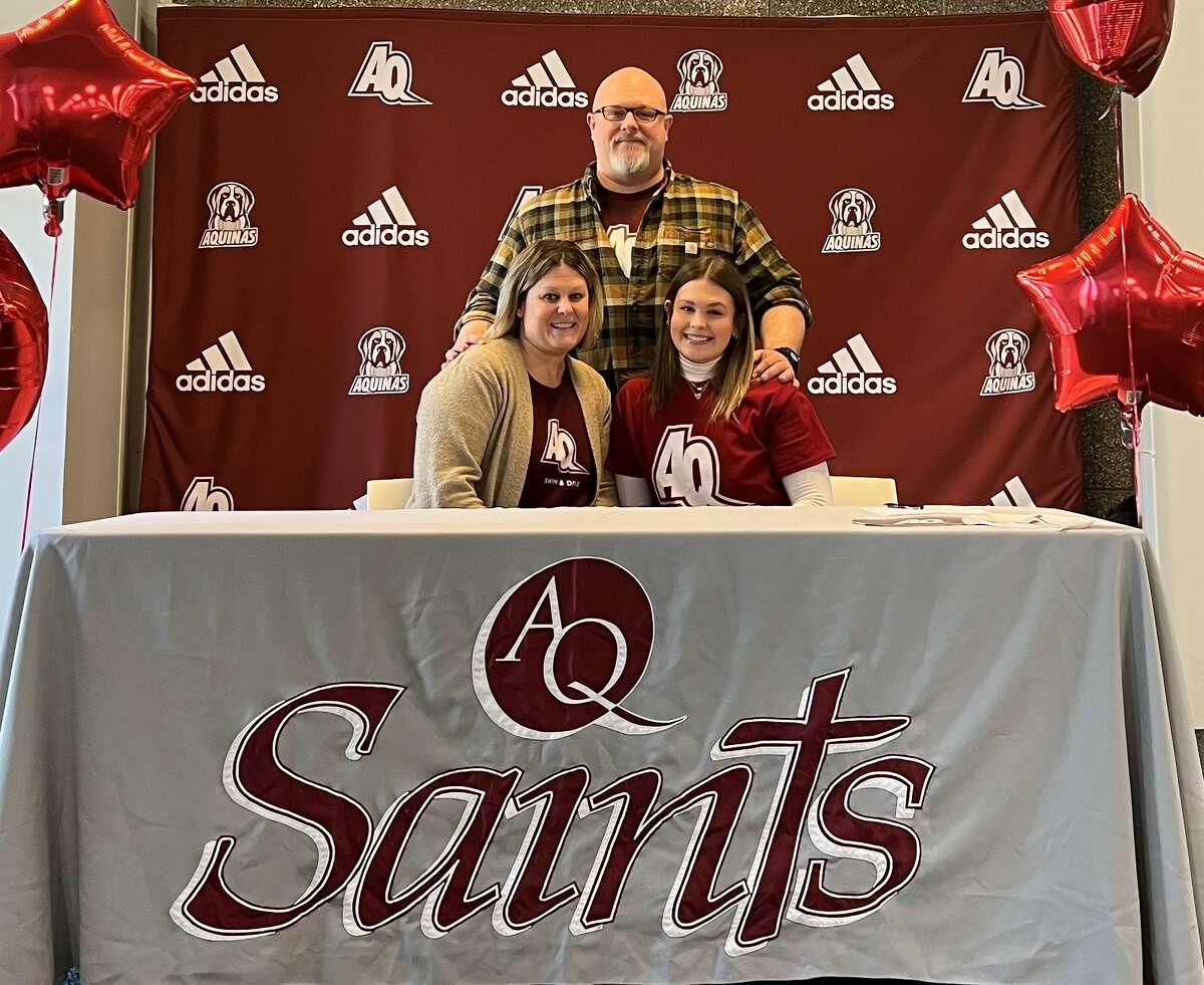 Lauren Mezeske (right) poses with her family after signing her letter of intent to swim collegiately for Aquinas College on Jan. 14 at Aquinas College. 
