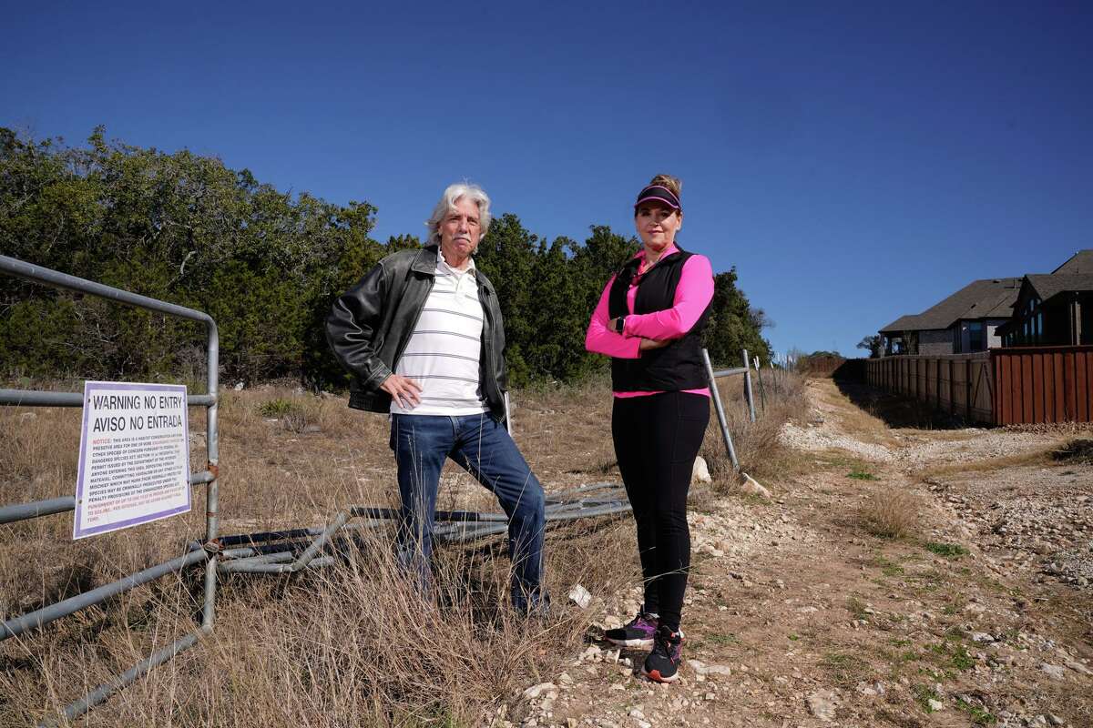 Bexar Audubon Society President Britt Coleman and resident Gina Smith pose during a tour of the Cibolo Canyon trail area where a development is planned on land set aside for habitat for the endangered golden-cheeked warbler.
