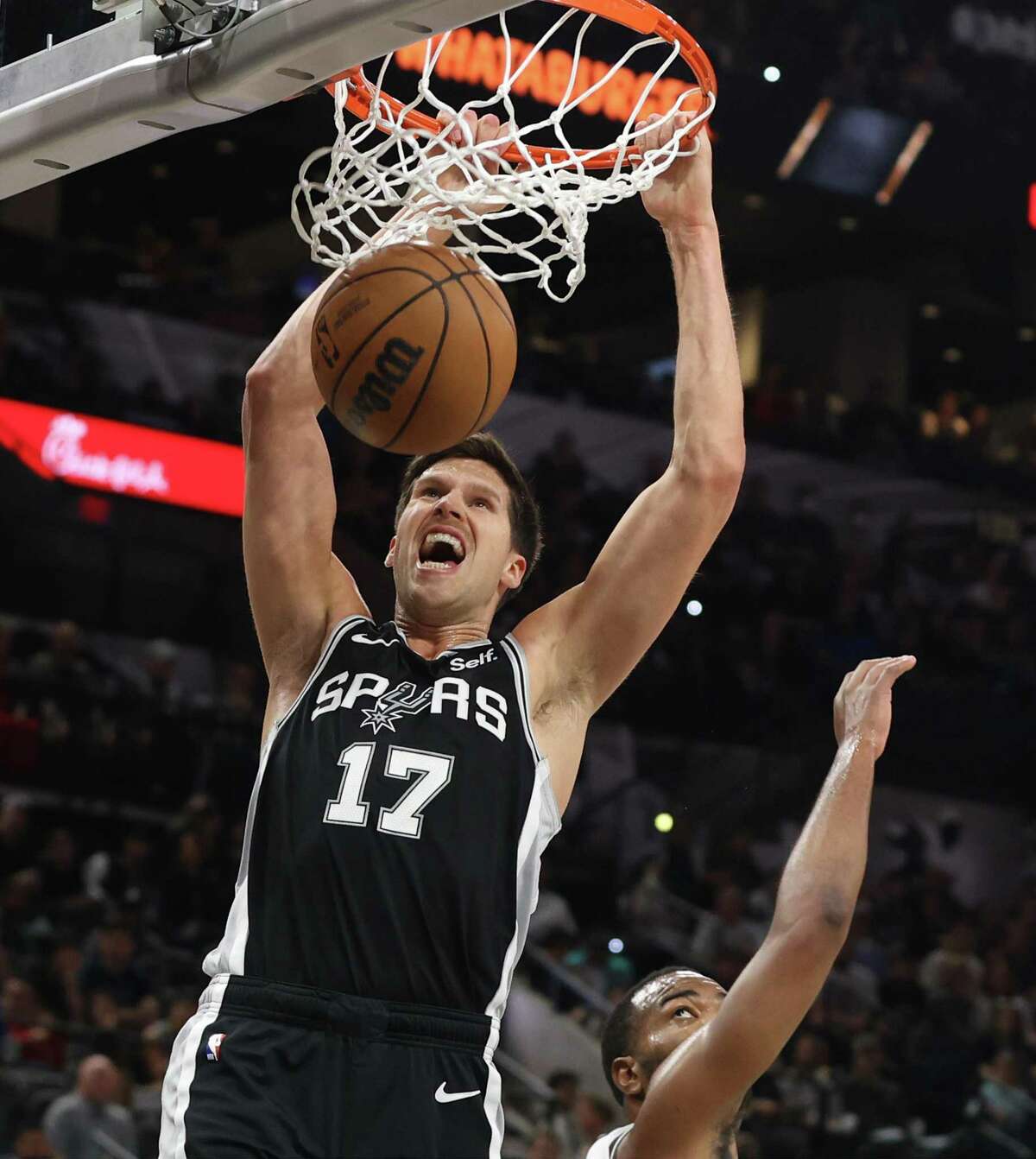The Spurs’ Doug McDermott dunks on the Brooklyn Nets’ T.J. Warren during Tuesday’s game at the AT&T Center.