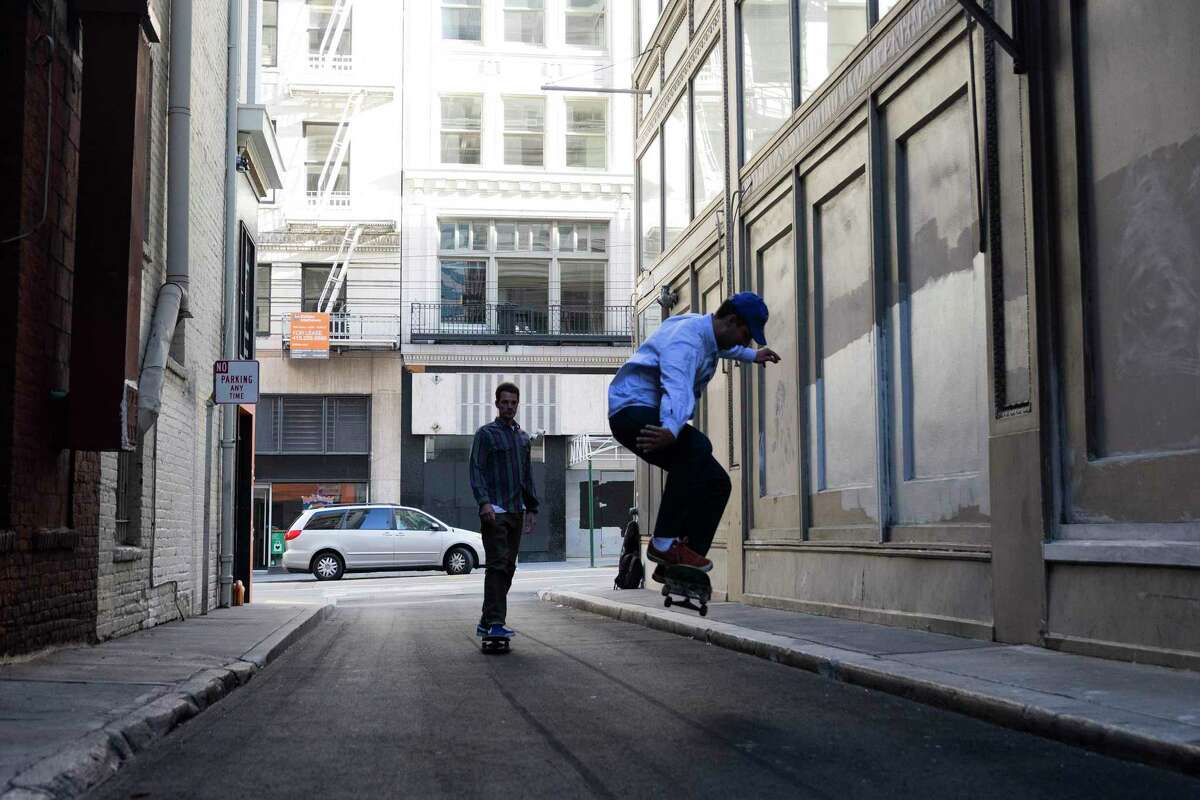 Two skaters ride through an empty Claude Lane in San Francisco’s Financial District last May.