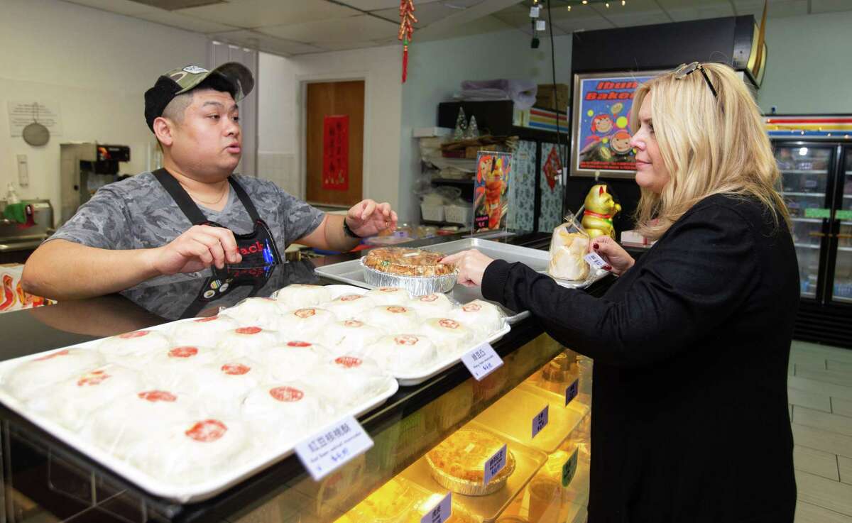 IBUN Bakery Owner Jack Su explains what’s in the rainbow rice cake, the main specialty the bakery has for the Lunar New Year, to Robin Davis Wednesday, Jan. 18, 2023, in Houston. Davis and daught were having lunch near by and decided to explore the bakery.