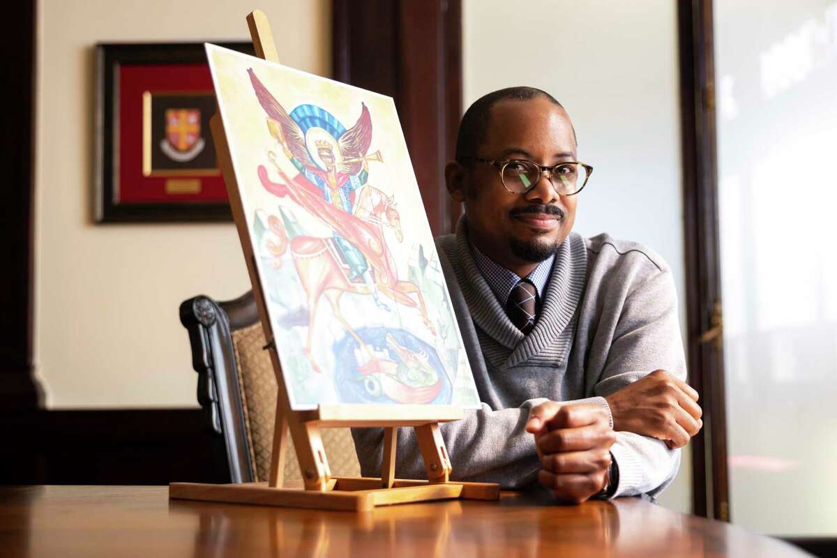 Sacred art artist and iconographer Al Sauls poses with one of his paintings of Saint Michael in the Link Lee Mansion at the University of St. Thomas on Friday, Jan. 13, 2023.