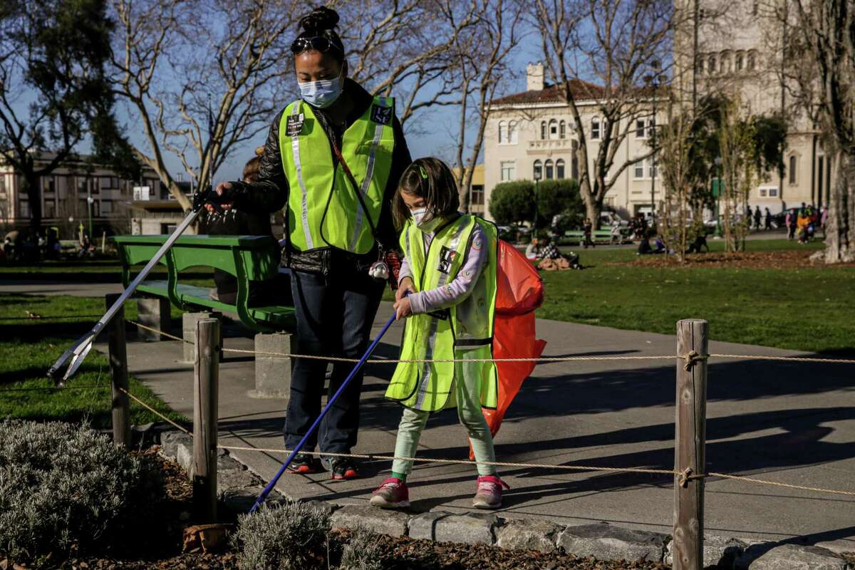 Marlis Ringseis picks up trash with Simone Yuen, 5, during a cleanup with the Refuse Refuse group started by San Francisco resident Vincent Yuen.