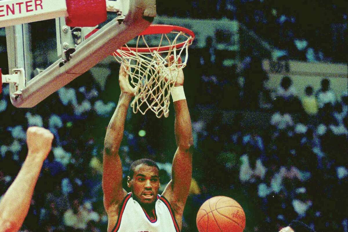 Scott Burrell of the University of Connecticut dunks the ball past Byrant Walton, right, and Brian Hendrick (15) of the University of California in the UConn-California game in the second round of the NCAA East Regional playoffs in Hartford, Conn., Saturday, March 17, 1990. (AP Photo/Bob Child)