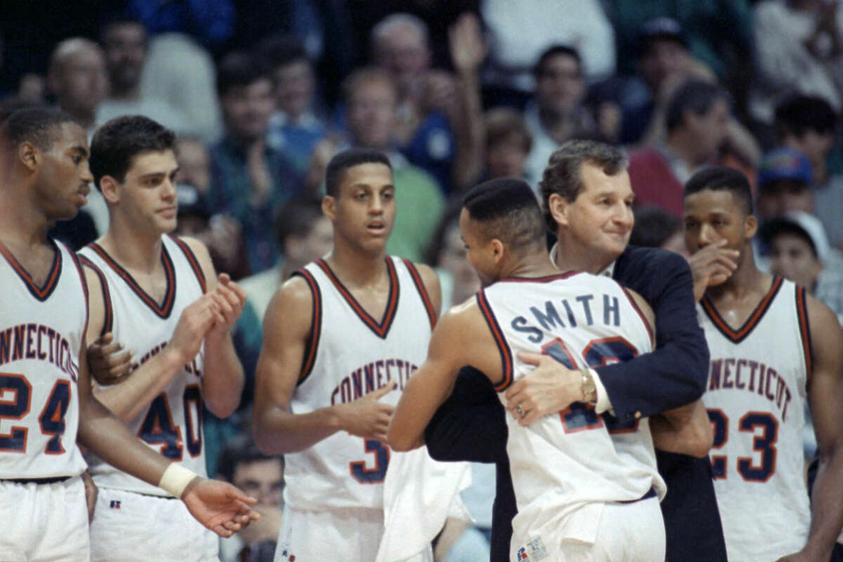 University of Connecticut head coach Jim Calhoun, second from right, hugs Chris Smith as he left the floor at the end of the UConn-University of California game in the second round of the NCAA East regional playoffs, Saturday, March 17, 1990, Hartford, Conn. UConn won the game 74-54 to advance to the quarter-final round. Other team members from left are Scott Burrell, Nadav Henefeld, Tate George and Lyman DePriest.