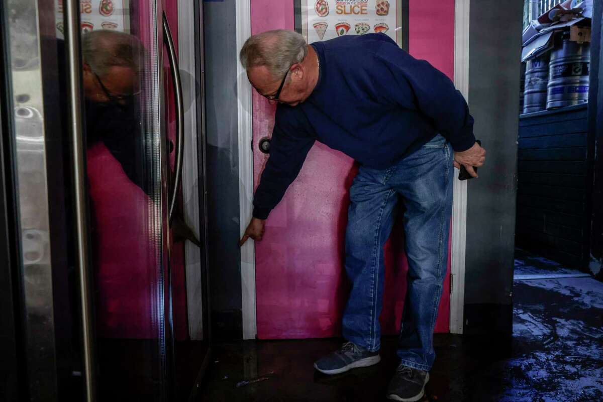 Angelo Coric points to where water levels hit after severe flooding on New Year’s Eve in San Francisco.