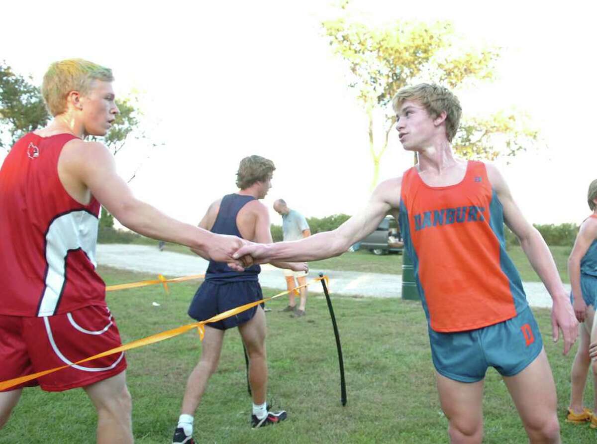 Victor Dahl of the Greenwich High School cross country team, left, shakes hands with Danbury High School's Alex Levine, right, just after Levine came in first in the boys race during meet at Greenwich Point, Tuesday, Oct. 12, 2010.