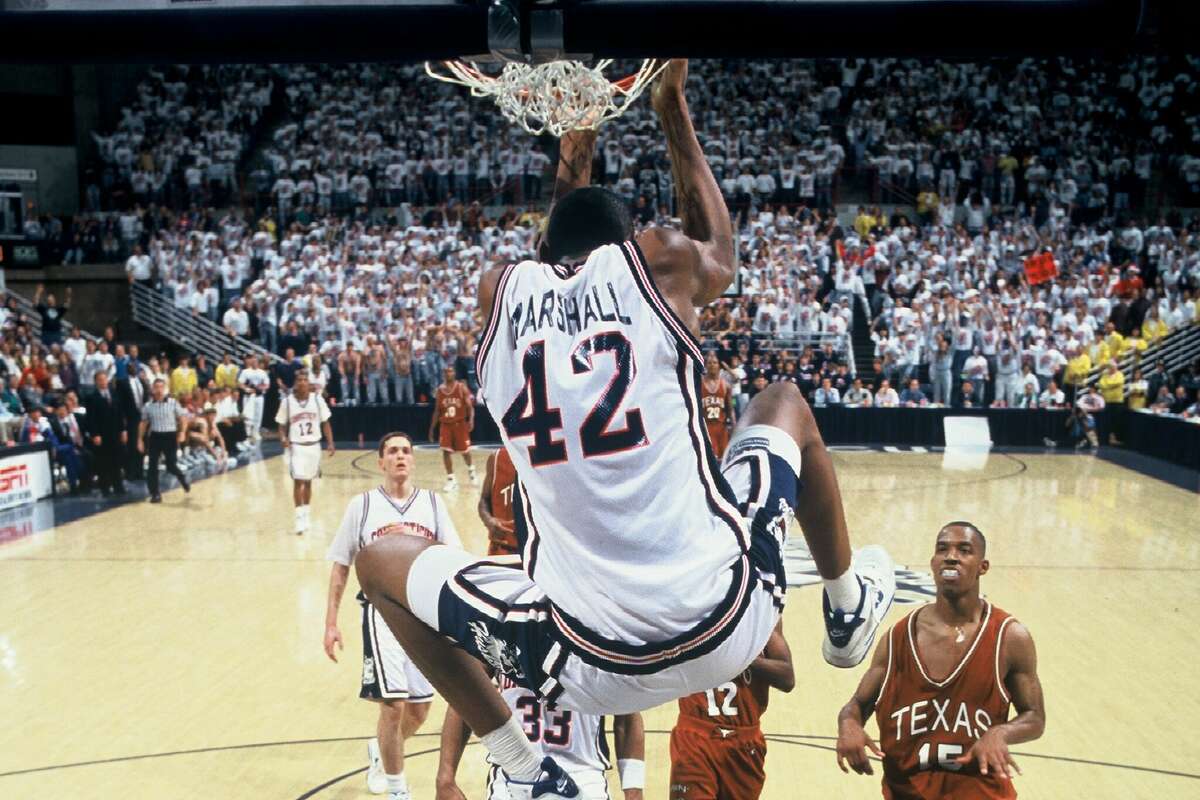 American basketball player Donyell Marshall of the University of Connecticut hangs from the hoop during a game against the University of Texas, Hartford, Connecticut, 1994. (photo by Bob Stowell/Getty Images)