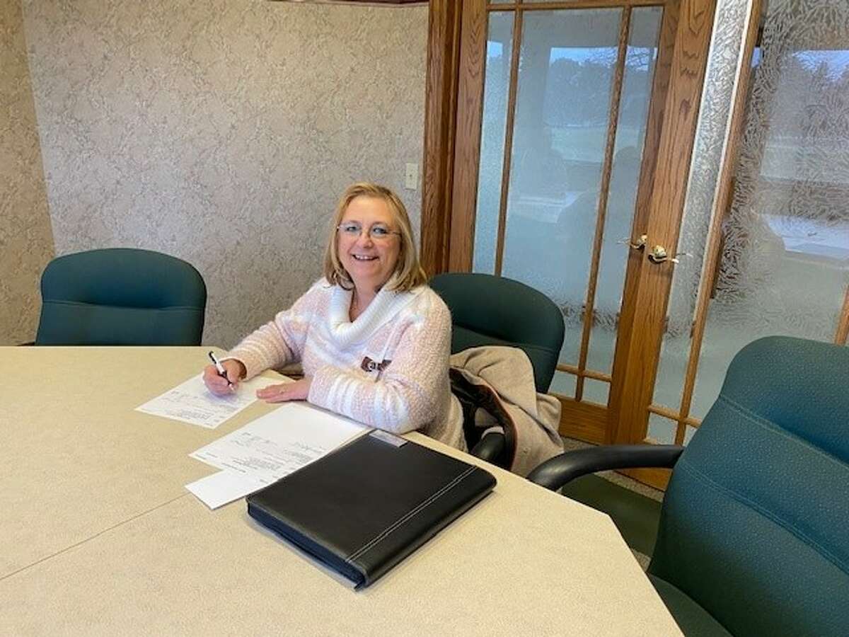 Cass City Manager Debbie Powell signs the documents for the village to officially purchase the land, which is 8.08 acres. 