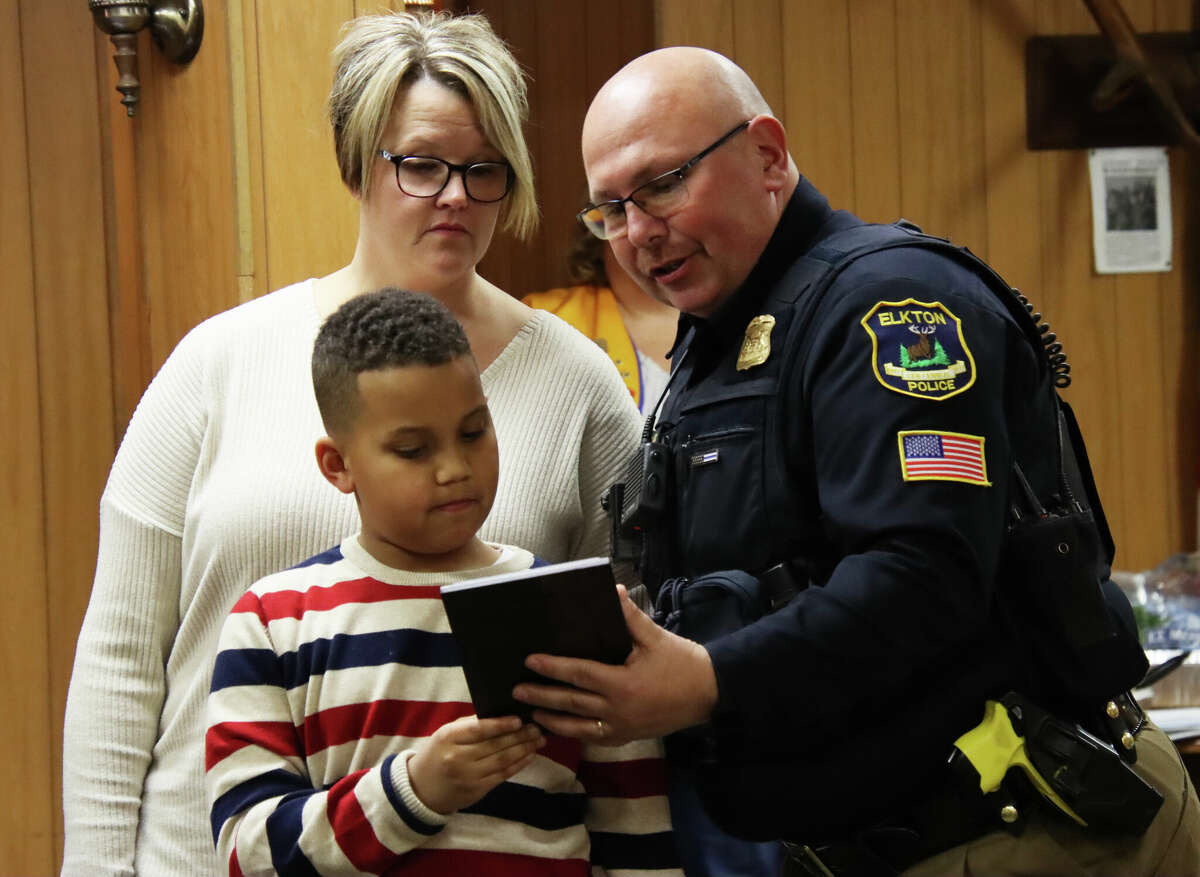 Eight-year-old Ayden Blake of Elkton was honored Wednesday night with awards of recognition for making a life-saving phone call after his father suffered a diabetic episode. Above, Elkton Police Scott Jobes, right, presents Ayden and his mom, Tracy Macdowall, with an award during the Elkton Lions Club meeting on Wednesday night.
