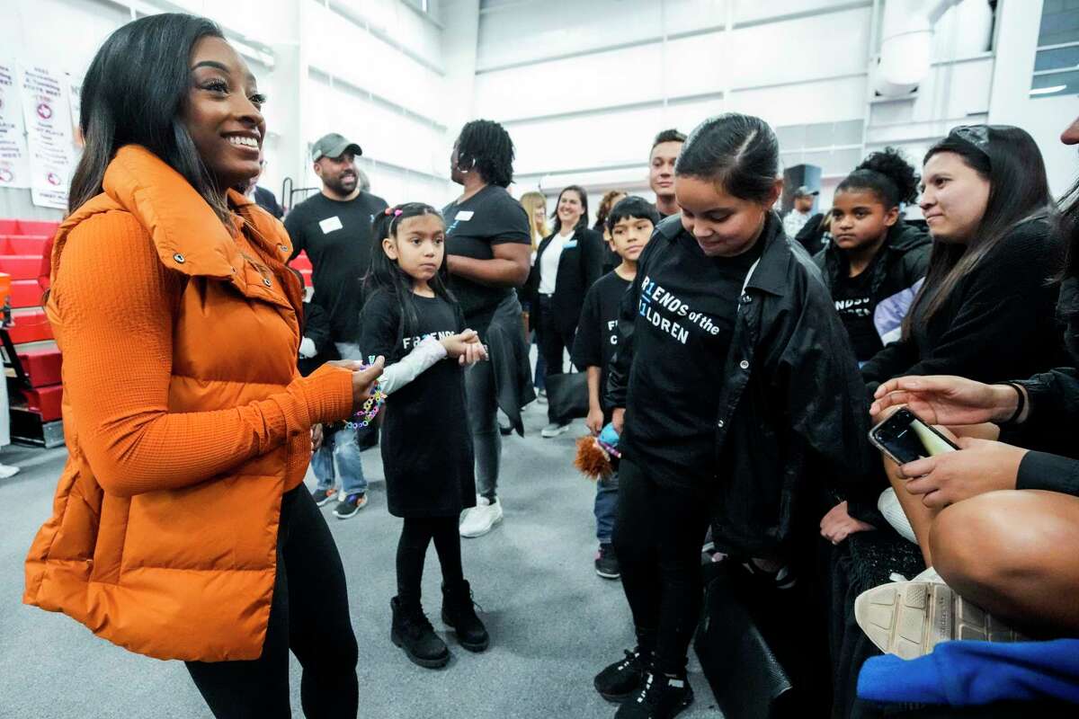 Olympic gold medalist Simone Biles, left talks with kids from Friends of the Children as she revealed her second Wheaties limited-edition box cover on Thursday, Jan. 19, 2023 in Spring. Friends of the Children is a national nonprofit committed to ongoing mentorship of youth, which will open a chapter in the Houston area this year.