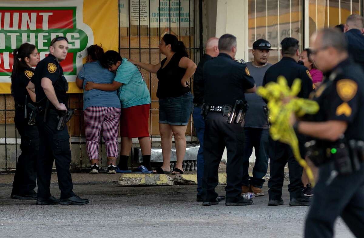 Family members of a young shooting victim from a shootout in Olmos Park comfort each other.