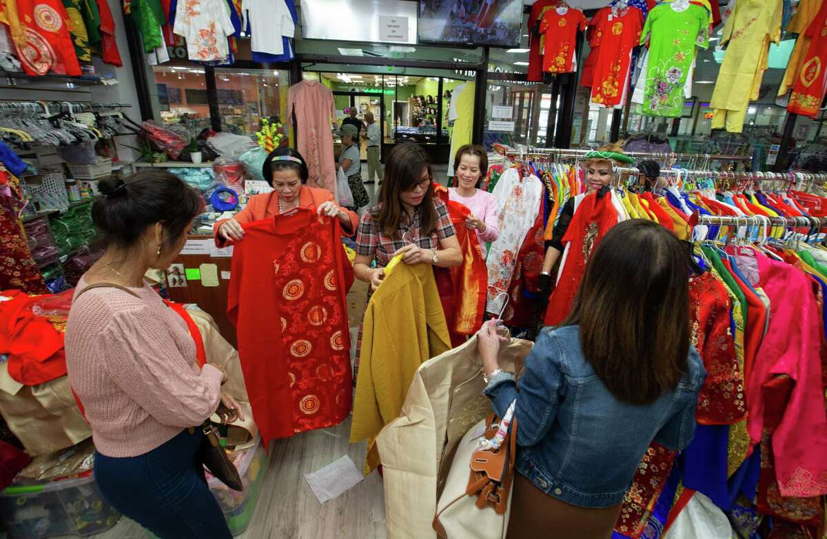 K-Fashion & More is busy with people buying new Ao Dai, traditional Vietnamese long dress, for Lunar New Year Thursday, Jan. 19, 2023, in Asiatown in Houston. Wearing new clothes is a part of the new year tradition to bring good luck.