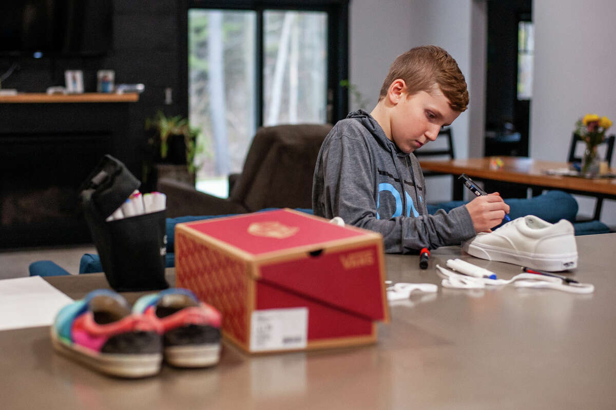 Sanford resident Jaxson Engler, 10, designs a pair of shoes for an ESPN fantasy football analyst on Jan. 18, 2023 in Sanford.