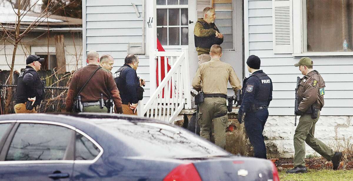 John Badman|The Telegraph Police officers from multiple agencies prepare to enter and search a house, with permission, in the first block of Rose Avenue in Cottage Hills Wednesday during the search for a male subject who fled a car that was reported stolen.  
