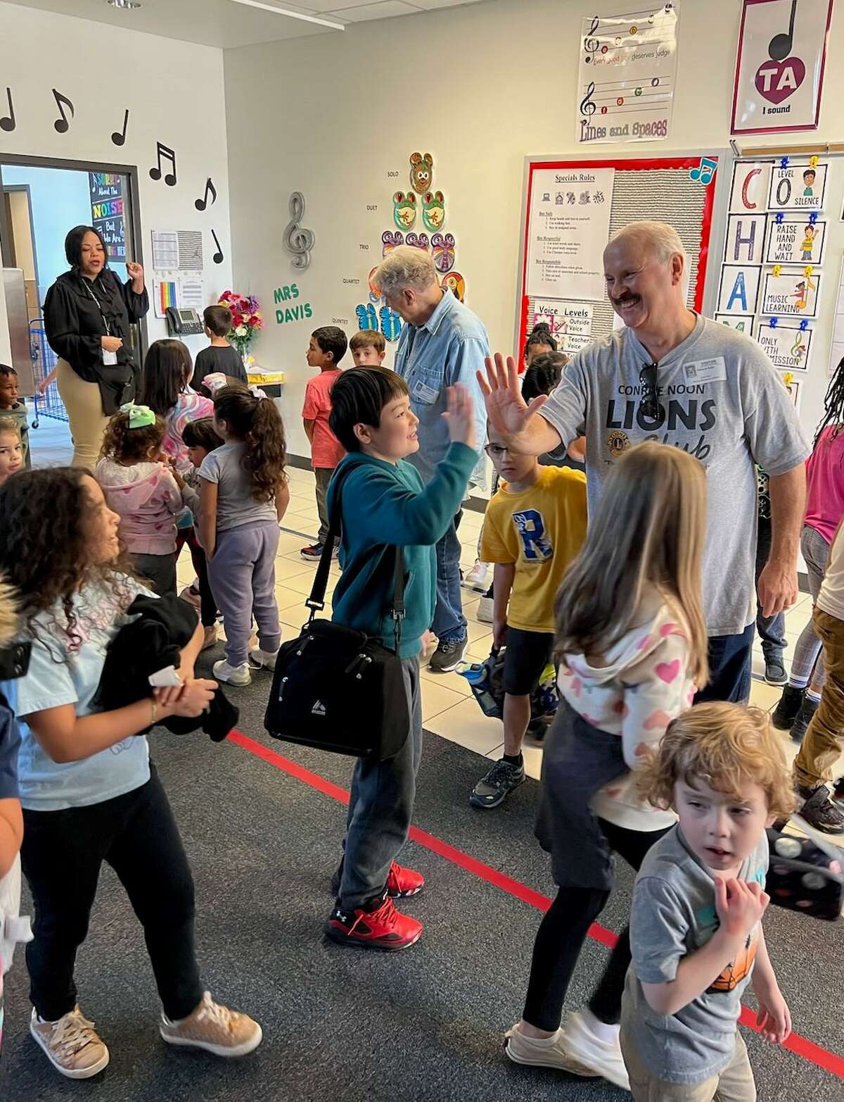High Five - Lion Ed Roth (center) is sharing a high-five with one of the students at their adopted school, Reaves Elementary. Last week the Conroe Noon Lions Club hosted treats during the school’s grading period rewards program ‘Atten-Dance’ congratulating students on perfect attendance and conduct.