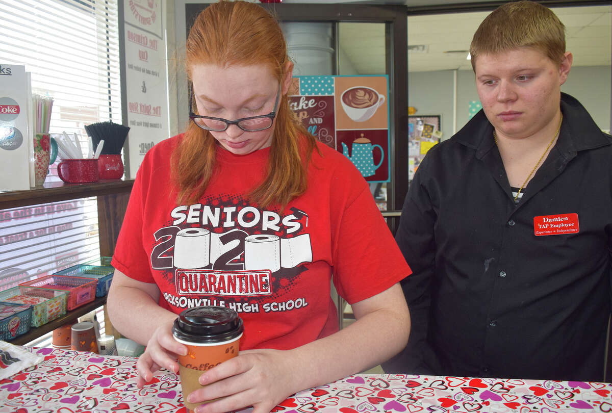 Piper Upchurch (left) and Damien Flynn, students of the Jacksonville Transitional Adult Program, prepare a cup of hot chocolate Friday at the Crimson Cup on the downtown Jacksonville square.