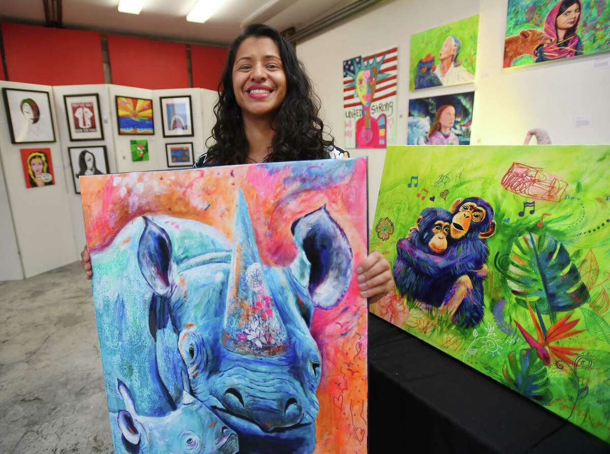 Nurse practitioner and professional artist Payal Emery, of Milford, with some of her fanciful animal portraits at the Firehouse Art Gallery in Milford, Conn. on Friday, January 20, 2023.