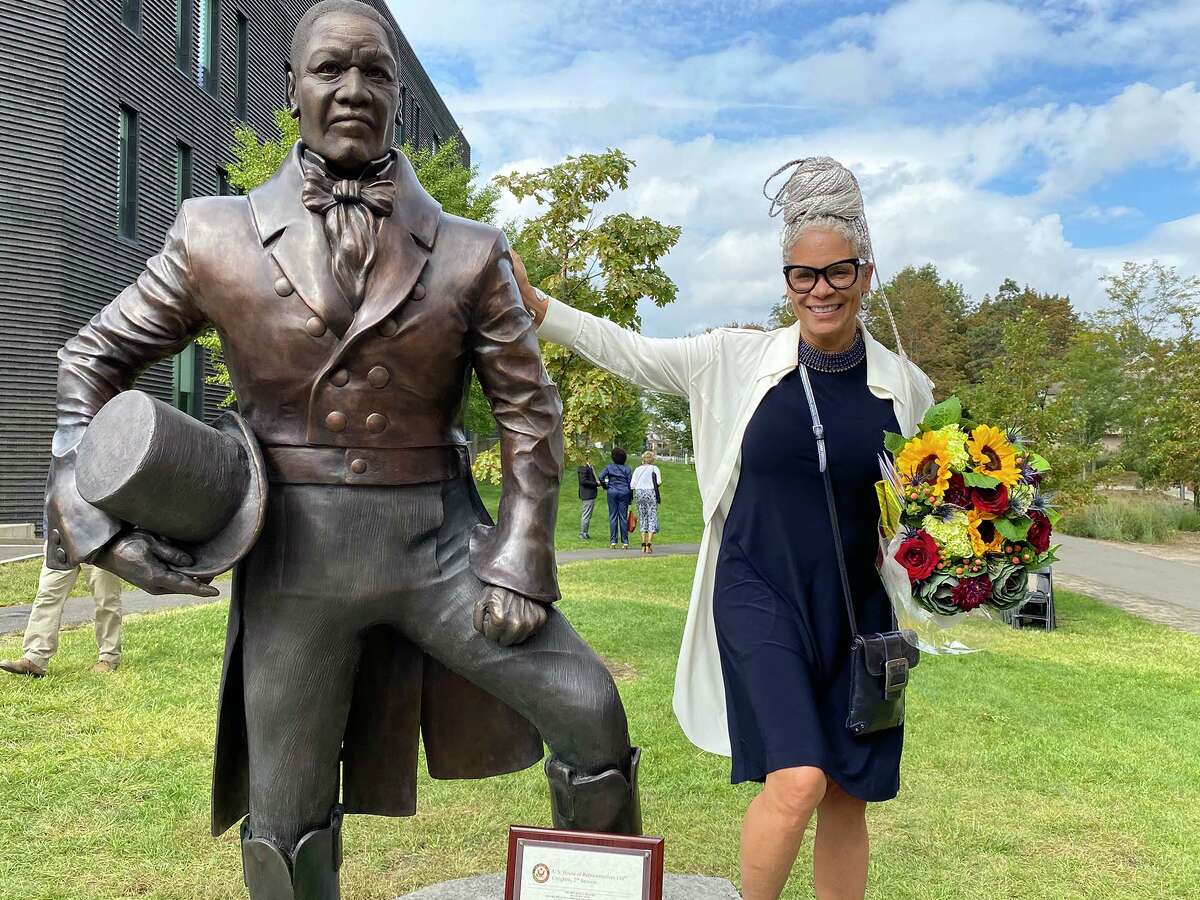 Sculptor Dana King poses with her statue of William Lanson after its unveiling ceremony in New Haven.