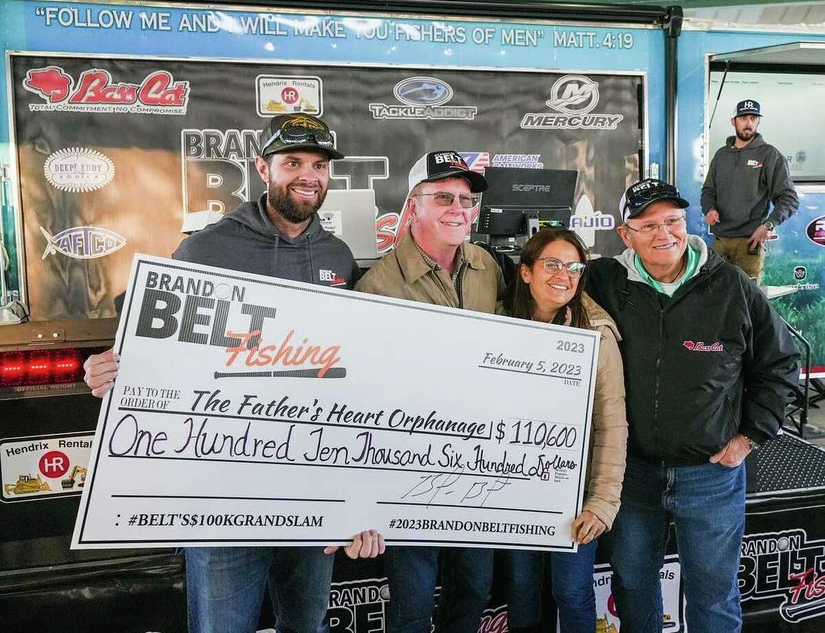 Tournament founder Brandon Belt (left) presents the donation to The Fathers Heart Orphanage founders Barry and Vania Hall, while Fishers of Men regional Director Dick Polk (far right) looks on. 