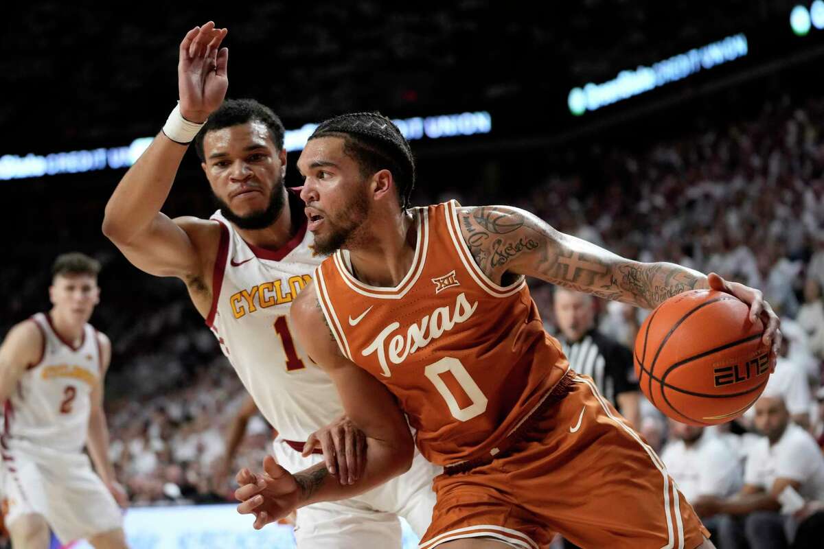 Texas forward Timmy Allen (0) drives past Iowa State guard Jaren Holmes during the first half of an NCAA college basketball game, Tuesday, Jan. 17, 2023, in Ames, Iowa. (AP Photo/Charlie Neibergall)