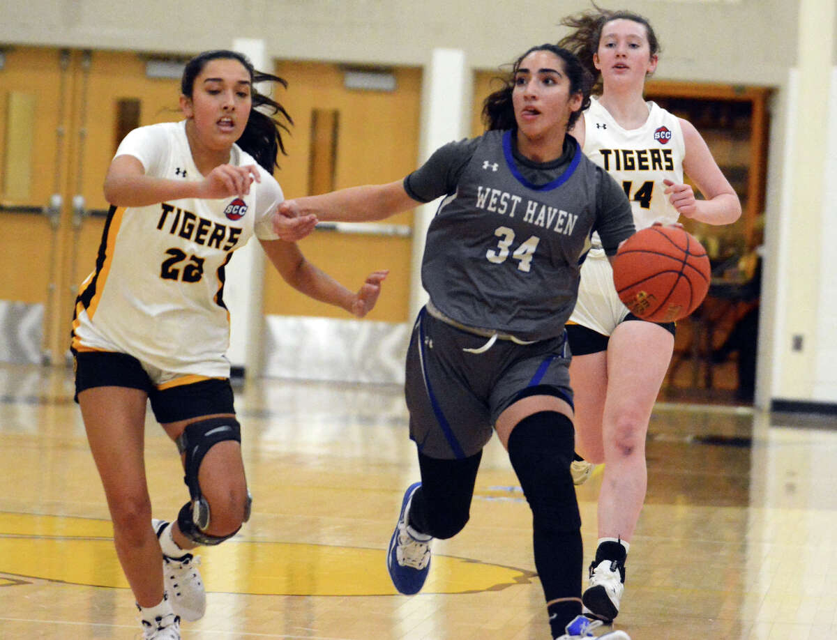 Amani Abuhatab races to the hoop while Aubrey Canth (22) of Hand chases her. Abbey Richard (14) trails the play in an SCC girls basketball game Friday, Jan. 20, 2023.