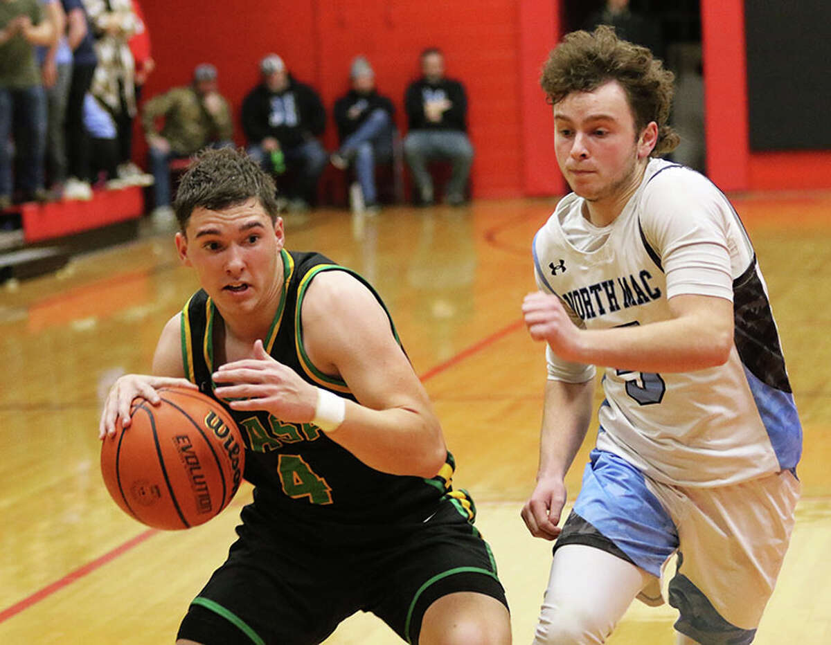 Southwestern's Lane Gage (left) takes the ball to the basket against North Mac's Dane Vance on Friday night in the championship game of the 104th Macoupin County Touranament at Hlafka Hall in Bunker Hill.