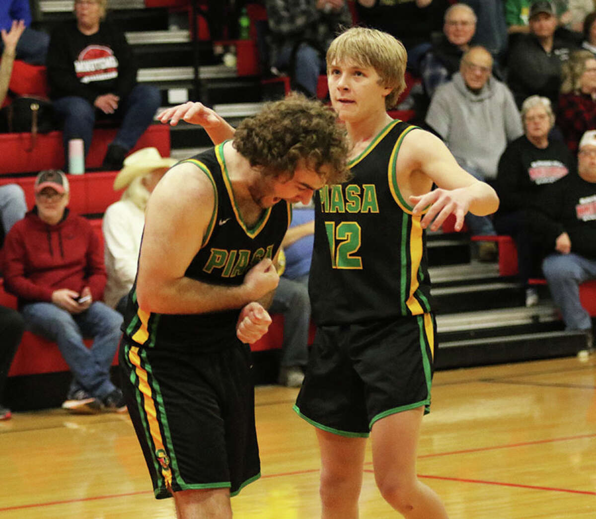 Southwestern's Hank Bouillon (left) reacts after making the first of two free throws with 0.8 seconds left in OT while teammate Rocky Darr looks at the clock on Friday night in the championship game of the 104th Macoupin County Touranament at Hlafka Hall in Bunker Hill.