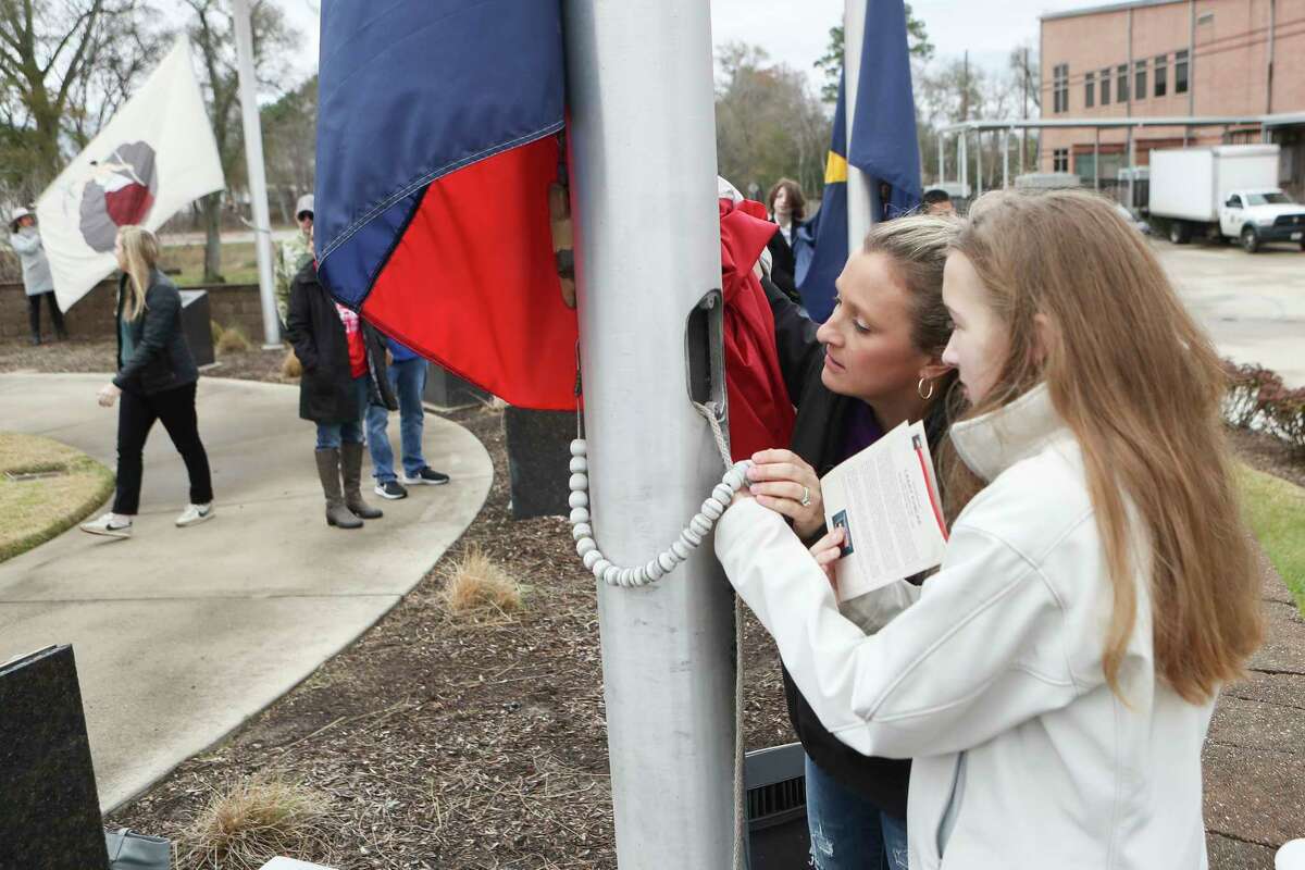 Melissa Gilsdorf, center, and her daughter, Addison Cruce, prepare the Texas state flag to be raises during a flag-raising ceremony in celebration of the 184th anniversary of the Texas state flag, Saturday, Jan. 21, 2023, in Conroe. The official flag of Texas was adopted by the Third Congress of the Republic of Texas on Jan. 25, 1839, in Houston.