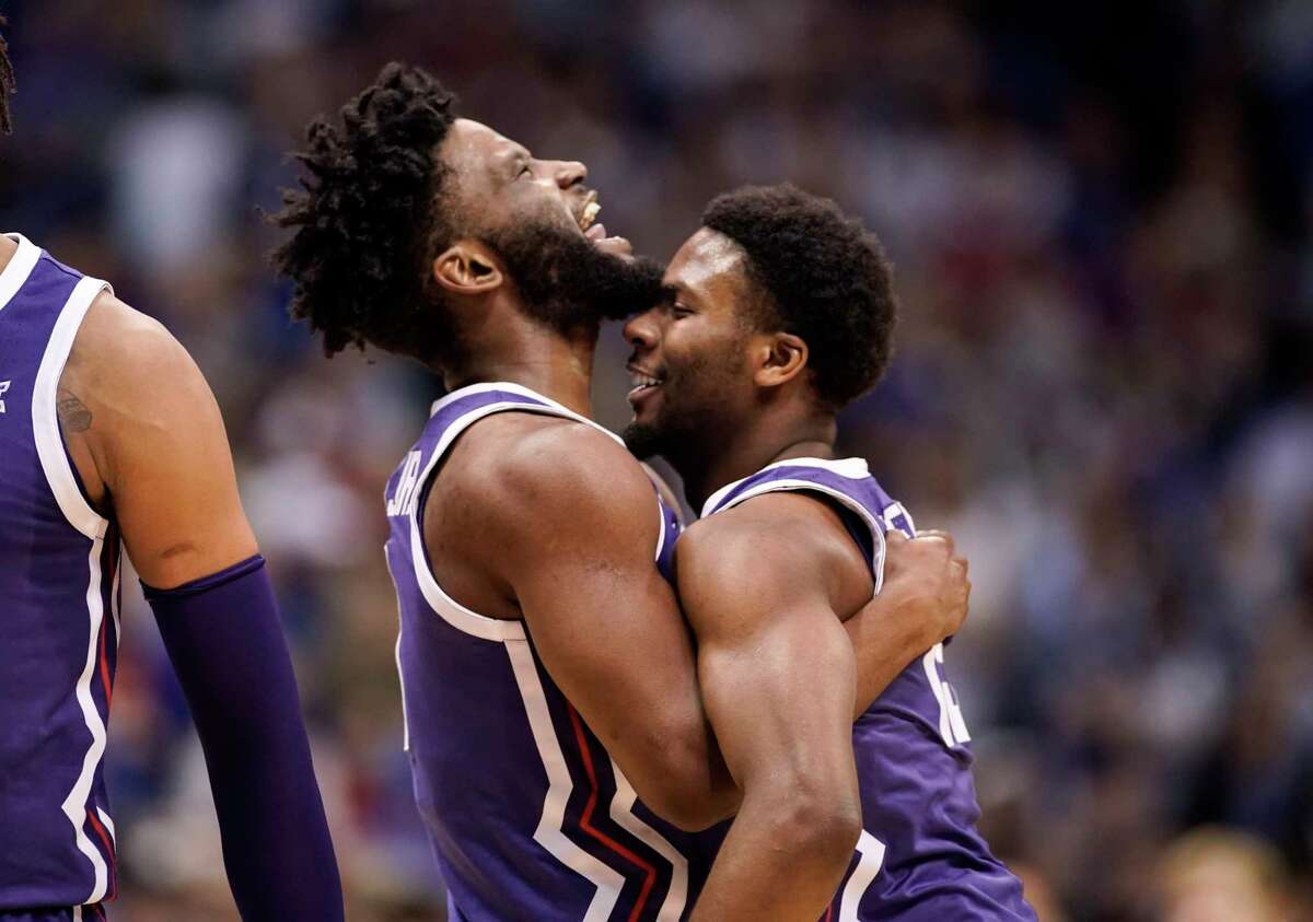 TCU guards Mike Miles Jr., left, and Shahada Wells (13) embrace during a timeout in the first half of an NCAA college basketball game against Kansas on Saturday, Jan. 21, 2023, at Allen Fieldhouse in Lawrence, Kan.