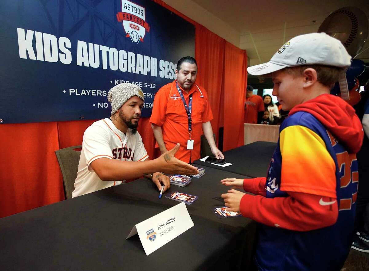 Houston Astros José Abreu reaches out to shake a young fan’s hand as he signed cards for fans during the Astros FanFest at Minute Maid Park on Saturday, Jan. 21, 2023 in Houston.